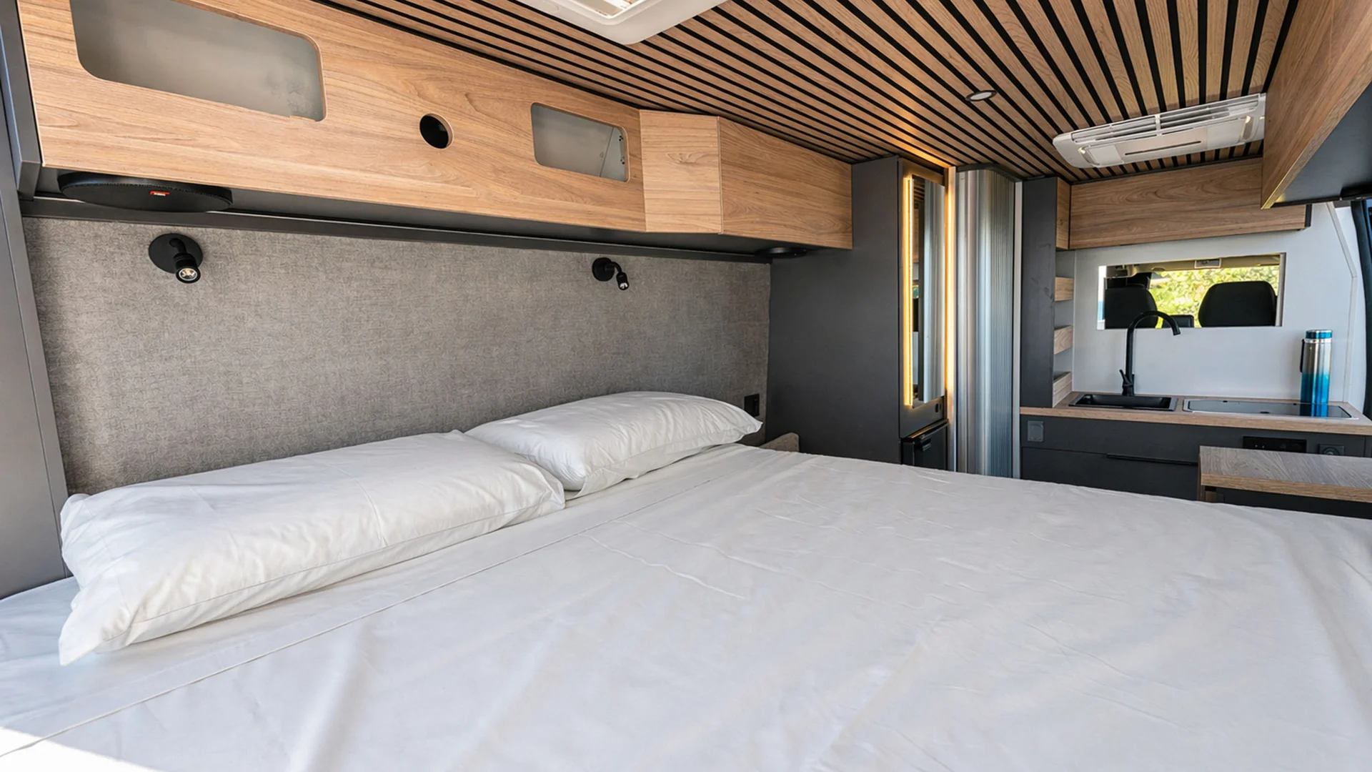 Modernes Camper-Innenraum mit Bett und kompakter Küche