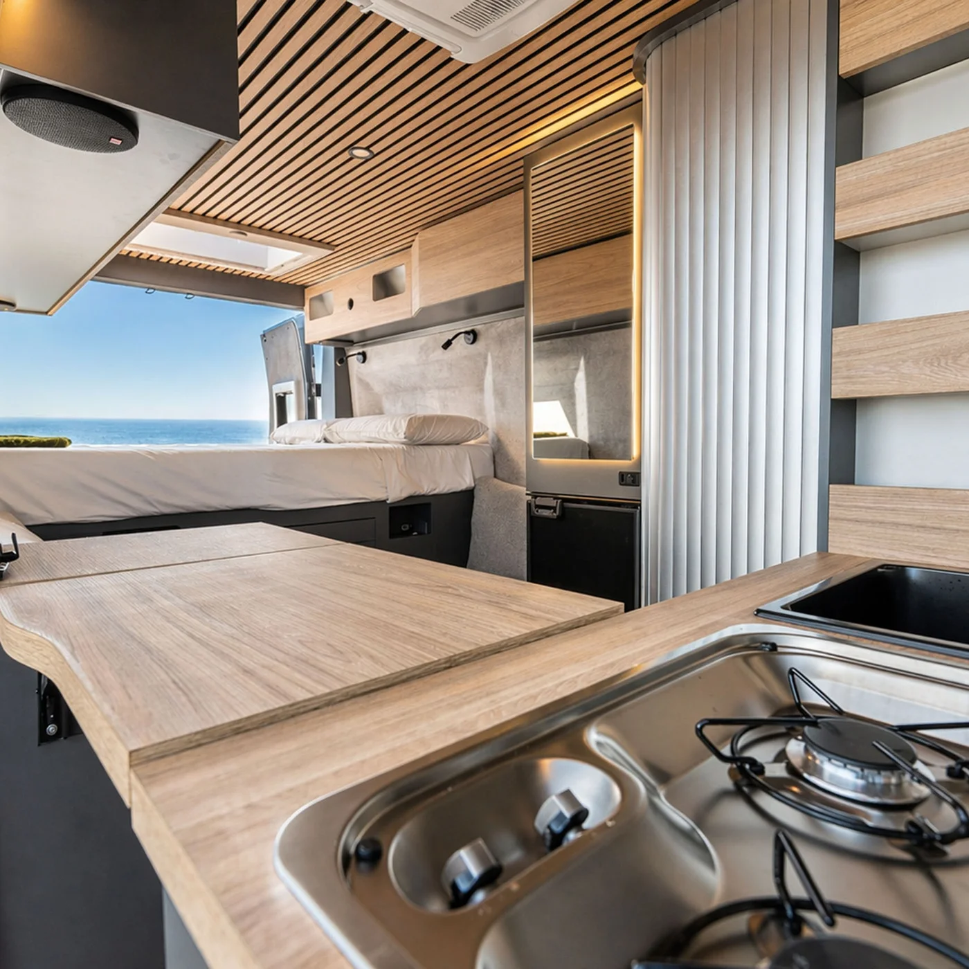 Modernes Camper-Innere mit Küche und Bett mit Meerblick