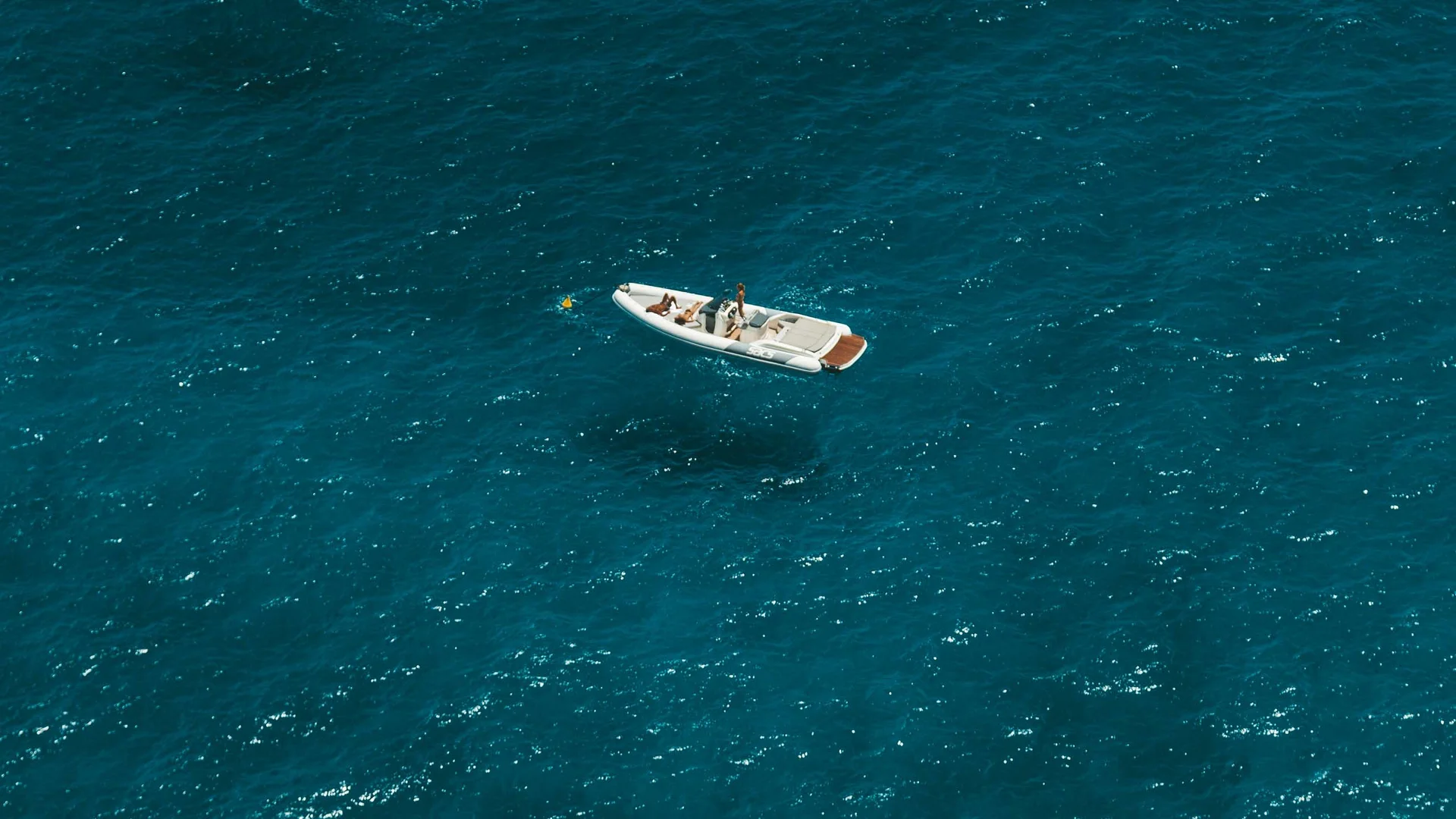 Tre barche bianche sparse su acque blu profonde