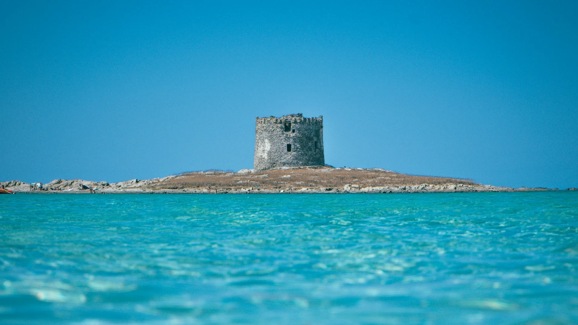 Torre su un'isola rocciosa circondata da acqua turchese