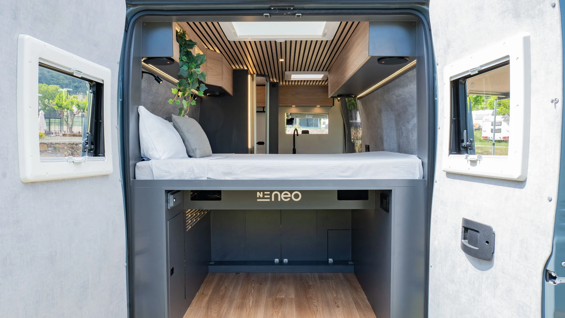 Interno di un camper moderno con letto e spazio di stivaggio sottostante