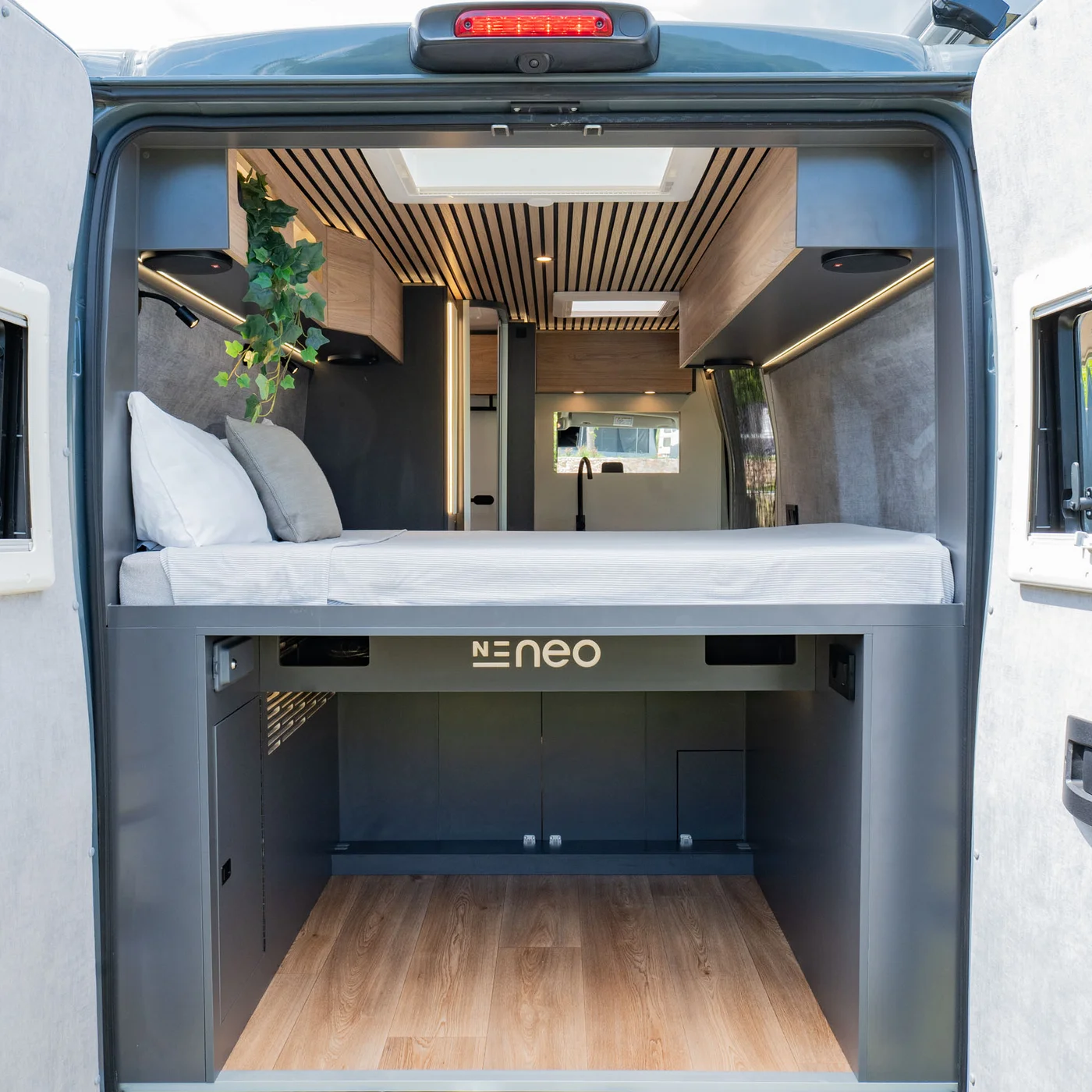 Interno di un camper moderno con letto e spazio di stivaggio sottostante