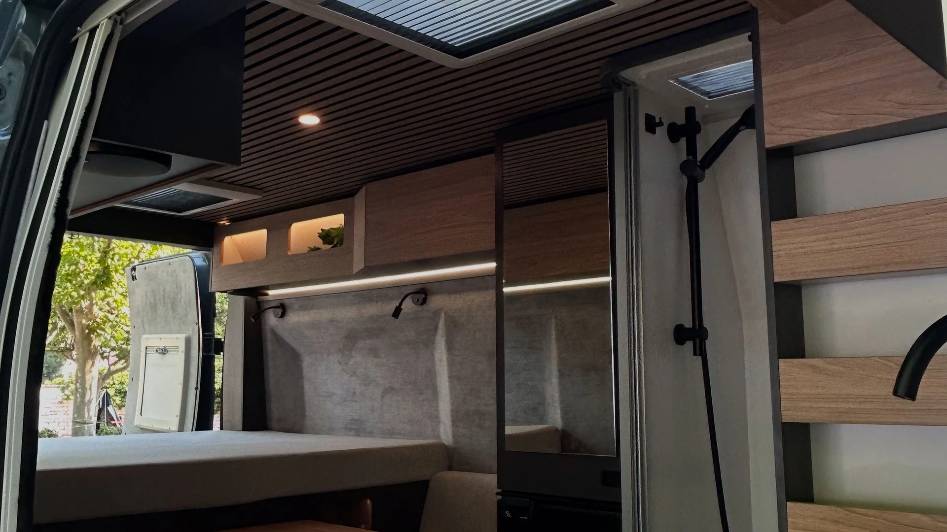 Interno di un camper moderno con cucina e area letto