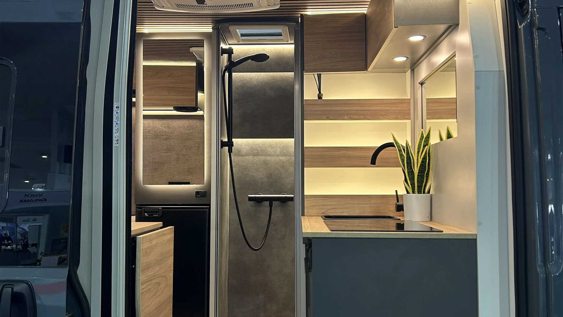 Interno moderno di un camper con cucina e doccia ben illuminata