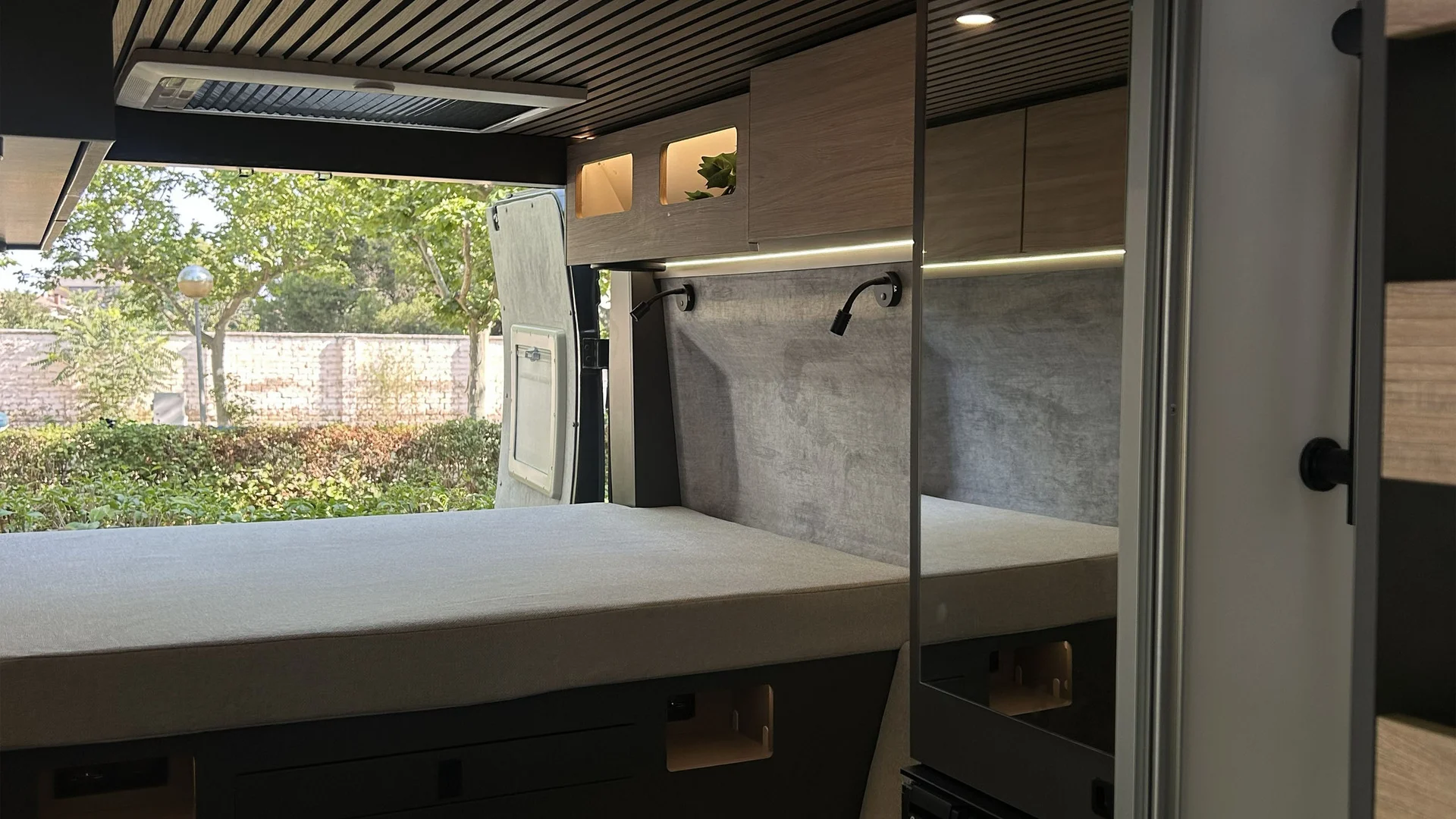 Interno moderno di camper con letto ampio e finestra sul tetto