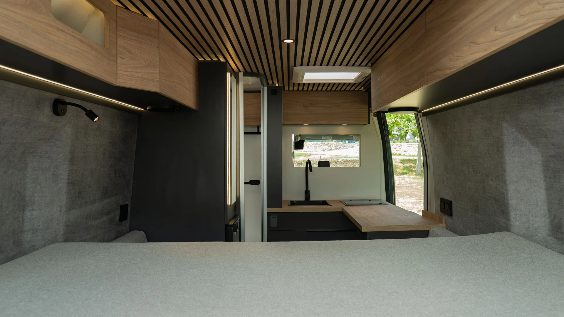 Interno moderno e minimalista di un camper con letto e cucina