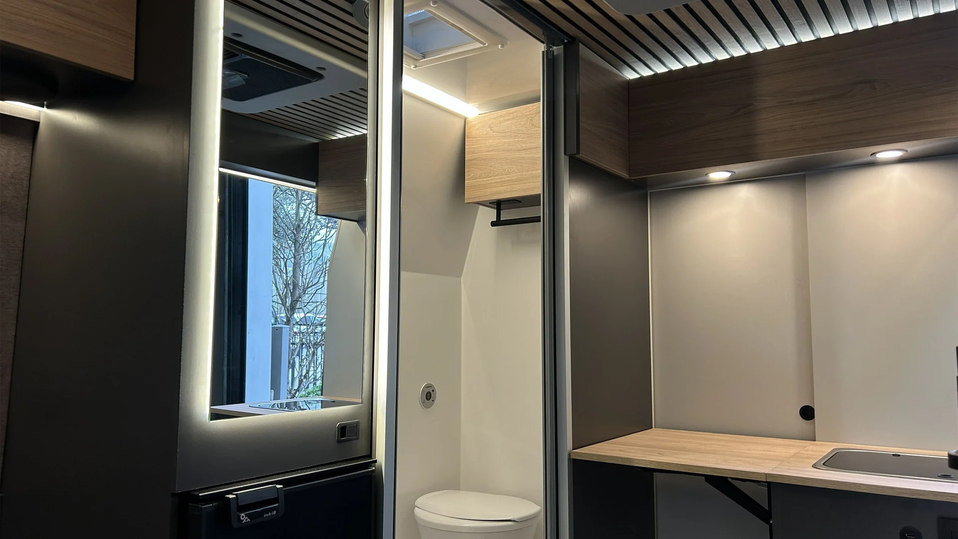 Interno di un camper con bagno compatto e cucina moderna