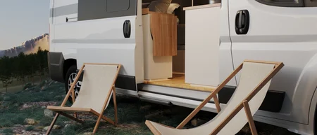 Camper bianco con due sedie sdraio in un paesaggio naturale