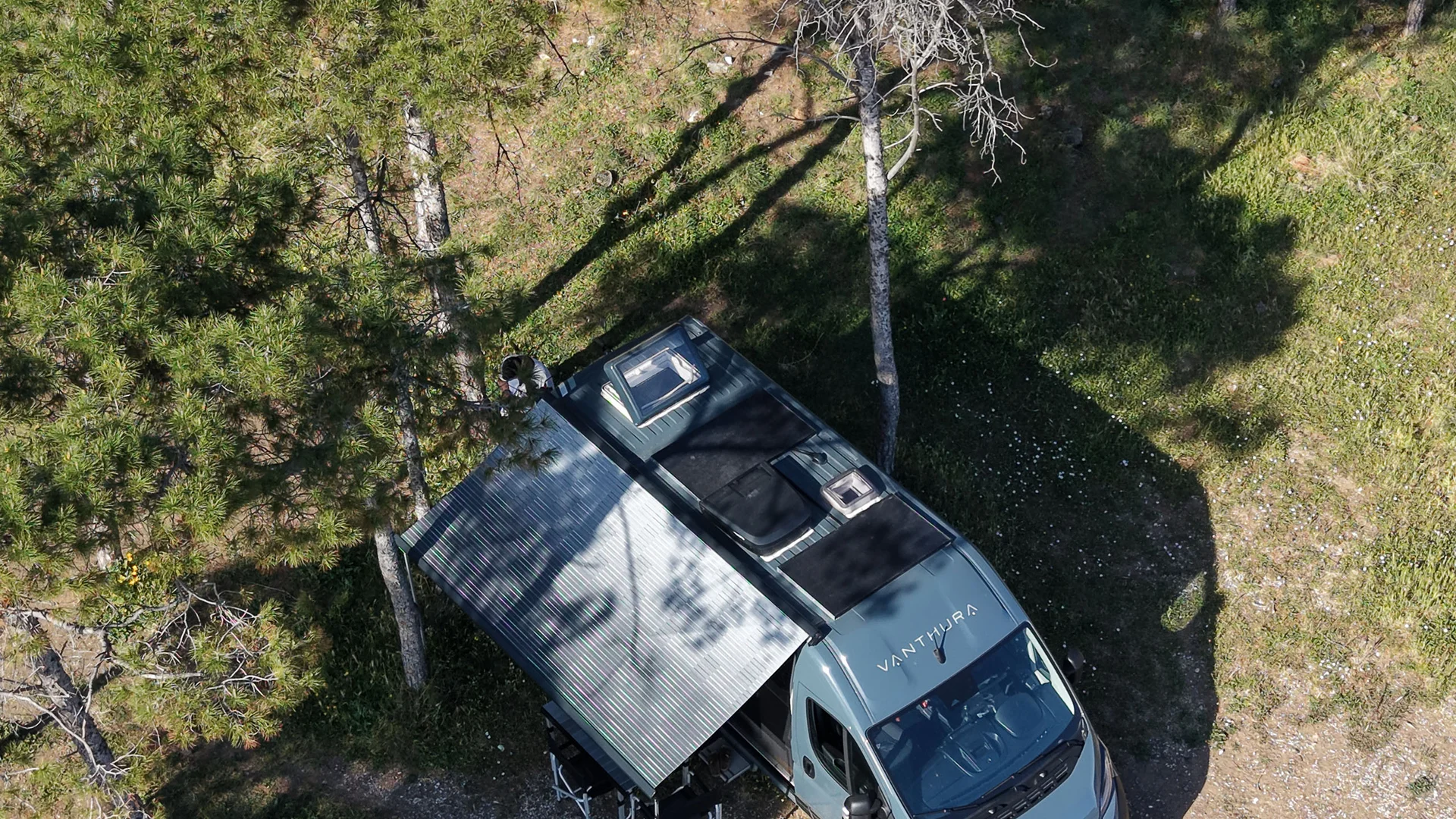 Wohnmobil in bewaldetem Gebiet mit Schatten und Bäumen geparkt