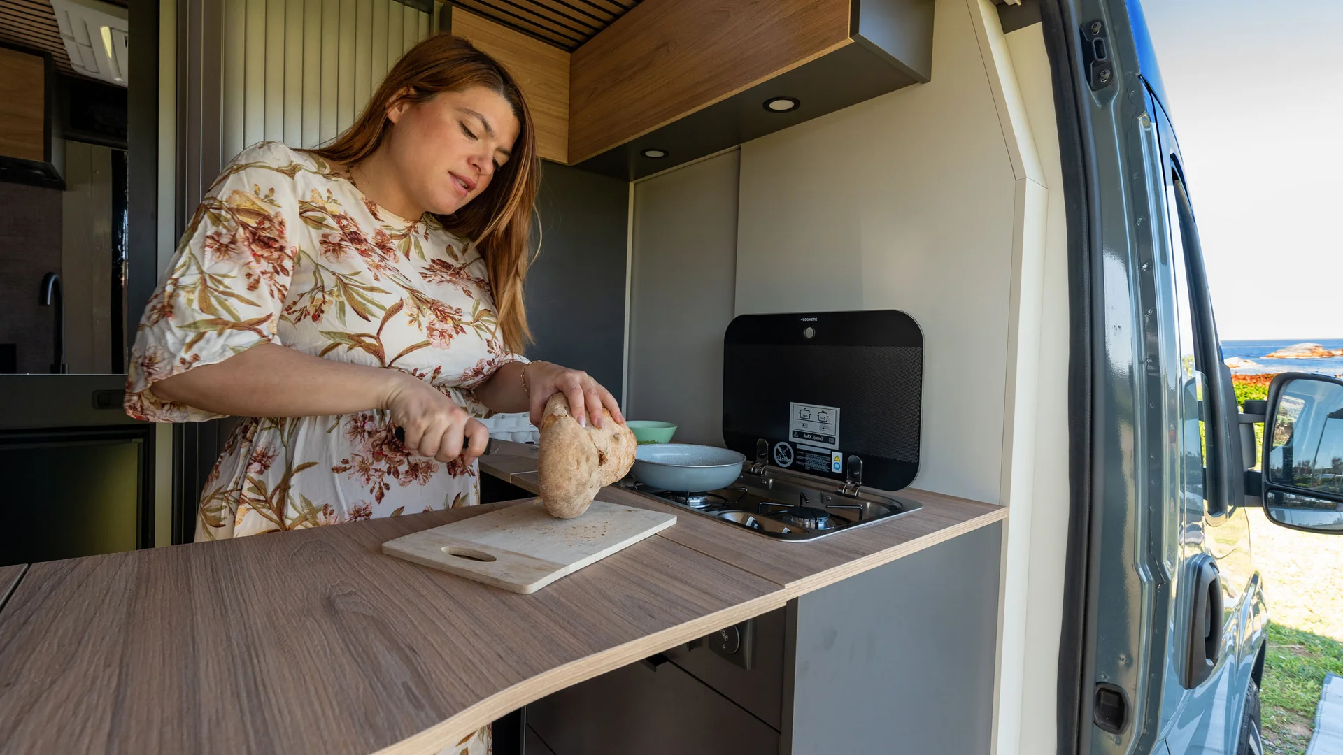 Frau schneidet Brot in einem Camper Van